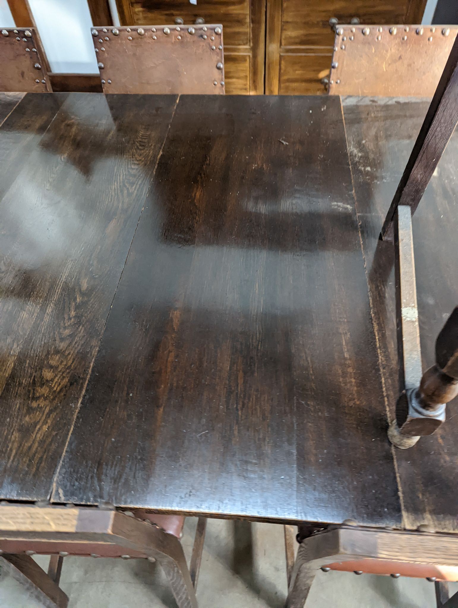 A 1920's oak extending dining table, 238cm extended (two spare leaves), width 120cm, height 74cm together with seven oak dining chairs (one with arms)